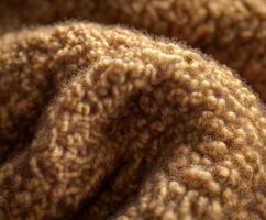 Textured fabric in warm brown hue showcasing intricate patterns and softness during daylight photo