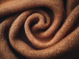 Soft and cozy brown fabric rolled in a spiral shape showcasing texture and warmth for textile enthusiasts and designers photo