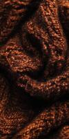 Textured brown knitted fabric showcasing intricate patterns and warm tones in a cozy indoor setting photo
