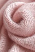 Textured boucle fabric in soft pink tones showcasing intricate fibers and gentle folds for cozy garment design photo