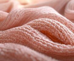 Soft boucle fabric texture in a warm peach color with gentle folds and waves illuminated by soft lighting photo