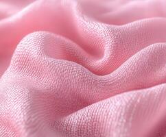 Boucle fabric texture in soft pink draping elegantly on a surface, showcasing intricate weave and luminous sheen photo