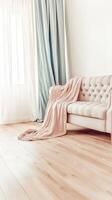 Cozy living room setup with soft blanket on sofa and natural light streaming through sheer curtains photo