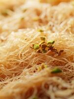 Delicious kunafa topped with crushed pistachios served on a warm platter at a dessert shop photo