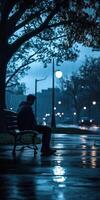 A man sitting on a bench in the rain photo