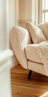 A white couch with pillows and a wooden floor photo