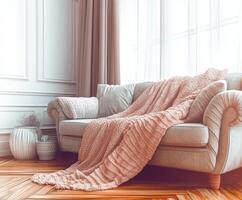 A couch is sitting in front of a window with a blanket photo