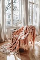 Cozy chair with knitted throw in sunny room photo
