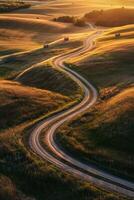A winding road in the middle of a field at sunset photo