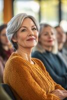 A woman sitting in front of a group of people photo