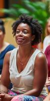 A woman sitting in a yoga class with other people photo