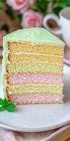 A slice of cake with a green, yellow and pink layer photo