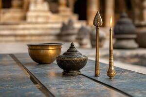 Buddhist ceremonial objects resting on wooden surface with burning candle photo