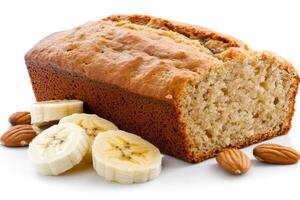 Freshly baked banana bread loaf is accompanied by banana slices and almonds photo