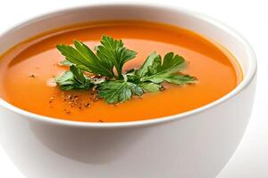 Creamy tomato soup seasoned with parsley and black pepper in a white bowl photo