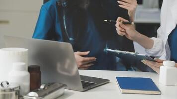 Two doctors are talking to each other at a desk video