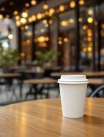 A coffee cup sitting on a table in front of a restaurant photo