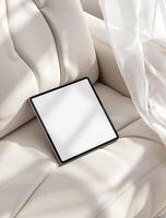 A white tablet is sitting on a couch photo