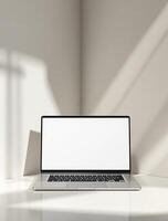 Laptop on a table in front of a white wall photo