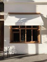 A white building with a wooden awning photo