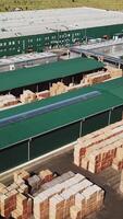 warehouse of plant manufacturing parquet. Aerial view. Camera motion to left Vertical video