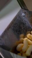 Snacks of corn making for kids. Sticks of corn making in the factory. Vertical video