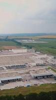 Modern industrial building surrounded by green fields. Large modern production plant Vertical video