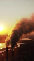 High-voltage tower sky background, factory pipe with smoke over it. Earth pollution and industrialization concept. Selective focus. Vertical video