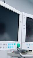 Two monitors of the modern medical equipment in the ward. One screen is black and another is switched on. Close up. Vertical video
