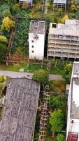 Old manufacture from above. Abandoned industrial territory with old buildings and warehouses. Empty factory. Orbital view.. Vertical video