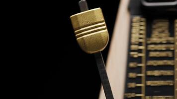 Pendulum swinging in slow motion on a metronome video