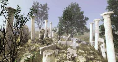 Ancient columns rise above lush greenery and rocky terrain, enveloped in fog video
