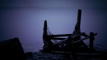 Mysterious twilight at a dock with a broken fishing net by a calm lake video