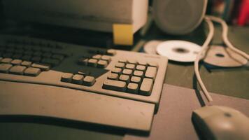 empoeirado computador teclado e rato em confuso escrivaninha com cds e caixas de som video