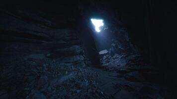 Exploring a dark cave with a bright light shining through the opening video