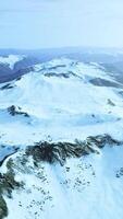 large snow patch left over on the volcanic rock field of a mountain in summer video