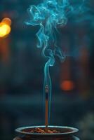 A burning incense stick in a bowl with smoke coming out of it photo