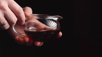 An elegant and captivating pour of a rich, dark liquid into a wellcrafted glass jug. Media video