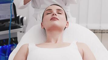 Close-up of a cosmetologist's hands polishing and cleansing the skin of a middle-aged woman face using a vacuum machine. Concept of skin care, rejuvenation. Advertising video