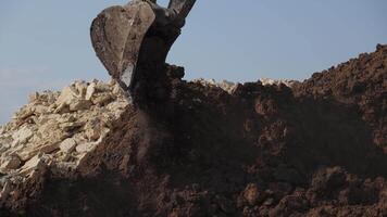 Observe the mighty excavator as it is actively engaged in the process of unloading earth. Clip video