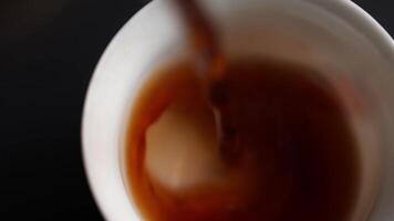 Pouring a steaming, hot beverage deeply into a cup creates an experience to savor. Media video