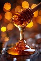 Honey dripping from a wooden stick on a wooden table with bokeh lights photo