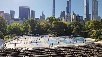 New York. US. 03.03.2025. Pickleball courts in Central Park with active players, surrounded by lush greenery and towering skyscrapers of Manhattan skyline video