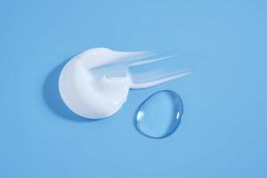 A smear of white cream And a drop of serum on a blue background. photo