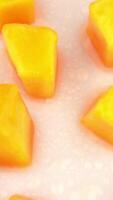 Juicy mango fruit slices rotating on turn table Isolated on white background Loopable Close up macro View from above overhead video