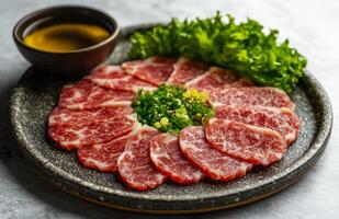 Raw beef on a plate with a bowl of sauce photo