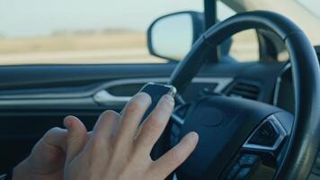 Close-up of driver hands using smartphone while driving car, risk of distraction and road safety concerns. Dangerous driving of vehicle, violation of traffic rules video