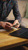 Man counting dollar banknotes, sitting in front of coffee table with laptop. Person managing budget at home, counts money in living room video