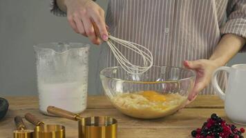 Egg yolk is blended with flour by the pastry chef in the kitchen as part of the process of preparing the dough, in order to add more density and viscosity to it. video