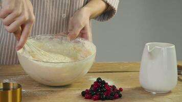 The chef prepares the dough and mixes it with flour to create a base for a blueberry pie, following a traditional American recipe. video